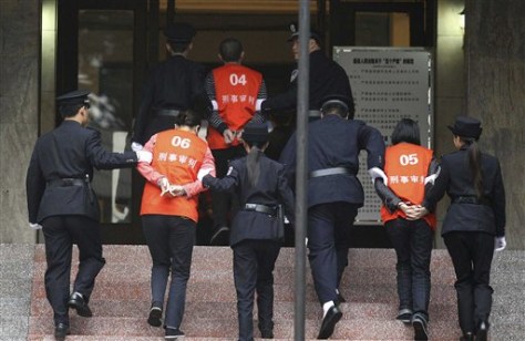 Image: Suspects involved in mafia-style gangs are escorted by police to stand trial at the Chongqing No.5 Intermediate People's Court in Chongqing, China