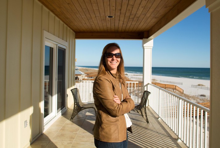 Image: Realtor Erin E. Kaiser stands on a deck of a house she owns in Gulf Shores, Ala.