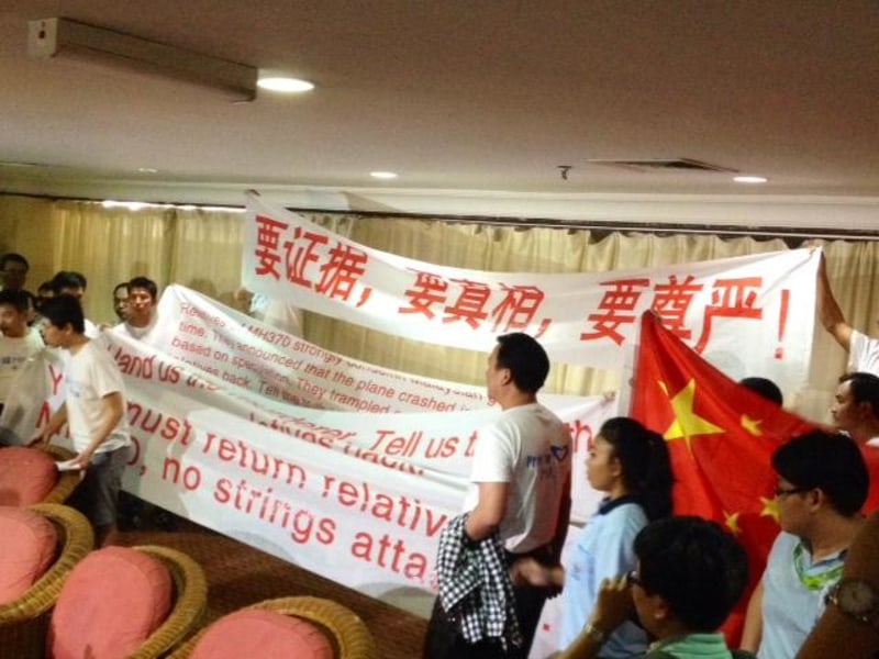 Image: Chinese relatives of passengers on missing Malaysia Airlines Flight 370 display banners and chant