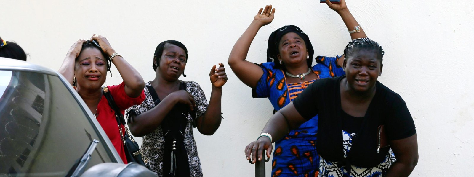 Image: Bystanders react as victims of a bomb blast arrive at the Asokoro General Hospital in Abuja