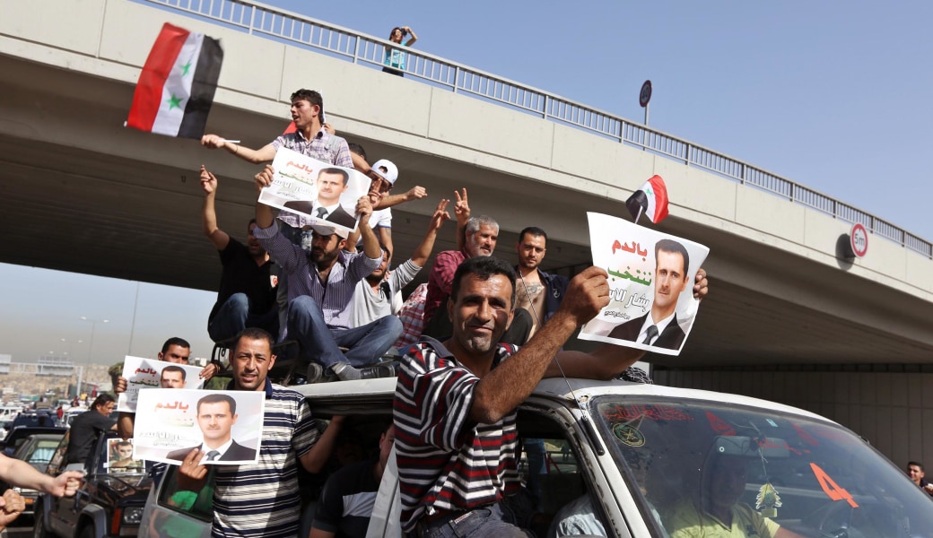 Image: Syrians who live in Lebanon carry portraits of Syrian President Bashar Assad and their national flags as they drive towards to the Syrian embassy to vote in the presidential election in Yarze, east of Beirut, Lebanon, Wednesday, May 28, 2014. 