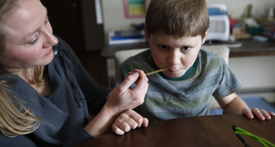 Image:  Nicole Gross uses an oral syringe to give her son Chase his daily dose of a medical marijuana oil, known as Charlotte's Web, at their home in Colorado Springs, Colo. 