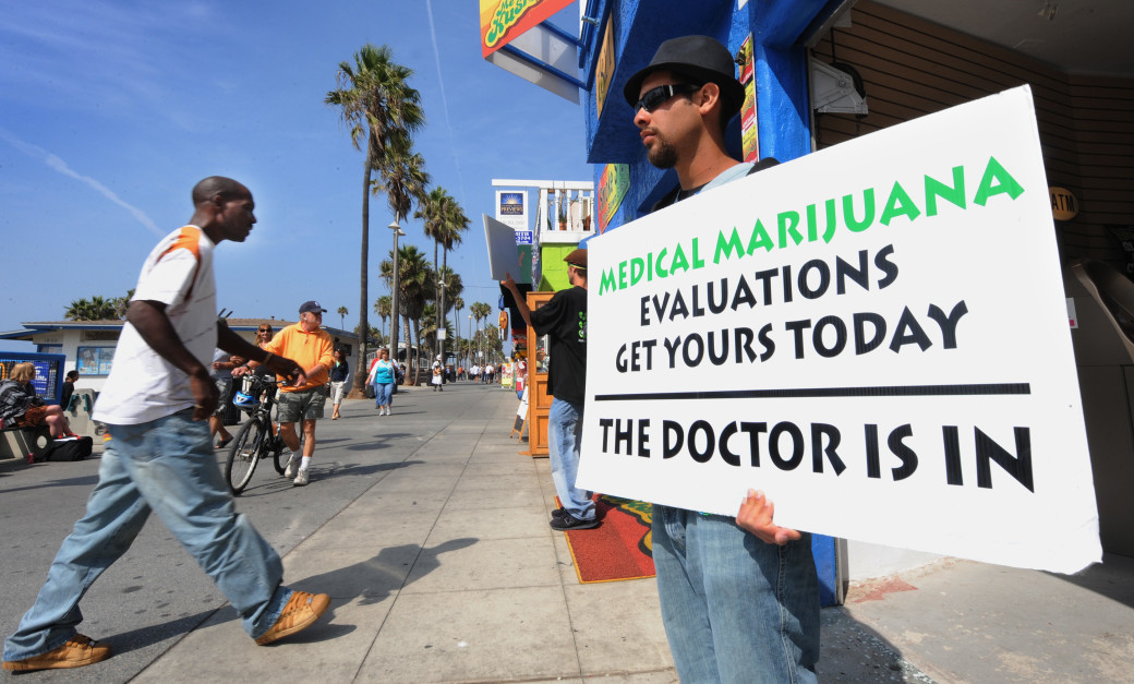 A man holds a placard advertising medica