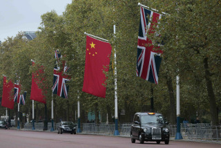 Image: A taxi drives past Chinese and British flags on the Mall in London