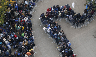 Image: Migrants line up outside Office of Health and Social Affairs as they wait to register in Berlin