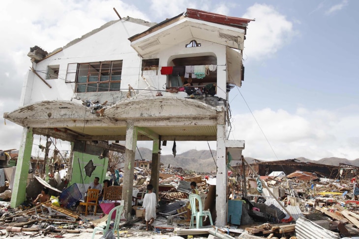 Survivors stay in their damaged house after Super Typhoon Haiyan battered Tacloban city, central Philippines.