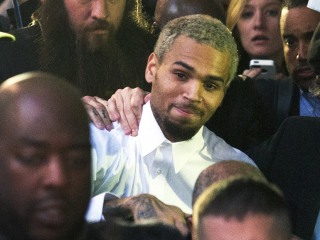 Singer Chris Brown, center, departs the H. Carl Moultriel courthouse Monday, Oct. 28, 2013, in Washington. A charge against the Grammy Award-winning R...