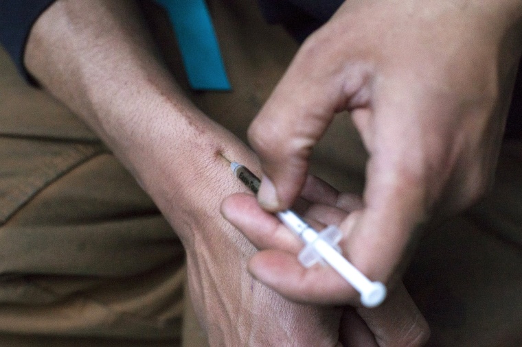 Image: A man injects himself with heroin using a needle obtained from the People's Harm Reduction Alliance, the nation's largest needle-exchange program, in Seattle, Washington
