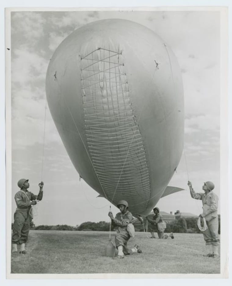 A crack Negro barrage balloon unit from Camp Tyson, Tenn., is one of the many features of the mammoth "BACK THE ATTACK" Army show now sparking $15,000,000,000, Third War Loan Drive in Washington D. C.; Members of the unit demonstrate how barrage balloons are used to protect ships, installations, bridges and cities from strafing by low-flying enemy planes." Roger Smith; Schomburg Center for Research in Black Culture, Photographs and Prints Division, The New York Public Library.