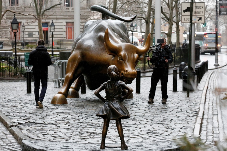 Image: A camera man films a statue of a girl facing the Wall St. Bull, as part of a campaign by U.S. fund manager State Street to push companies to put women on their boards, in the financial district in New York