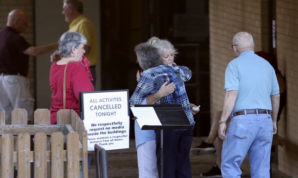 Image: People greet each other outside First Baptist Church after hearing news of the deaths of several members