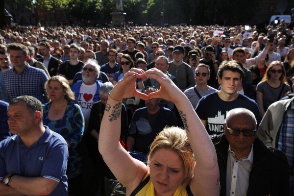 Image: A woman makes a heart gesture as crowds gather