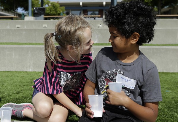 Image: campers Gracie, left, leans toward Nugget during an activity at the Bay Area Rainbow Day Camp in El Cerrito, Calif.