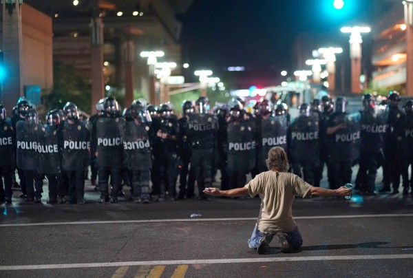 Image: A demonstrator taunts police while Trump speaks in Phoenix, Arizona.