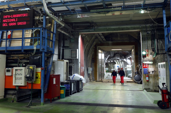 Two researchers walk down the long corridor in a nuclear physics laboratory