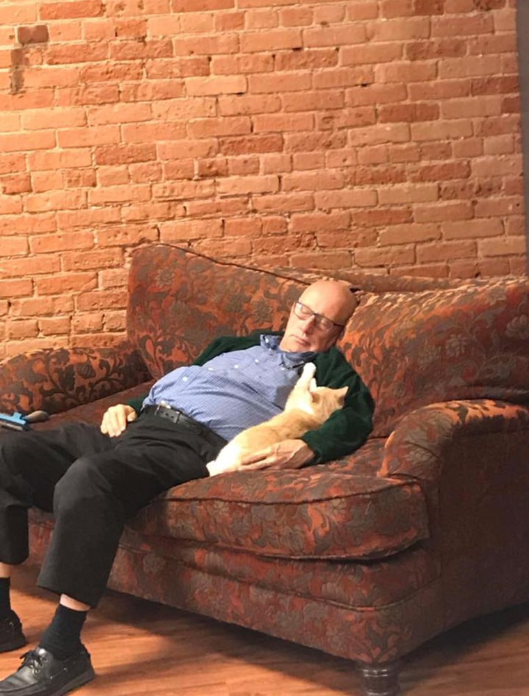 volunteer Terry sleeping with sanctuary cat 