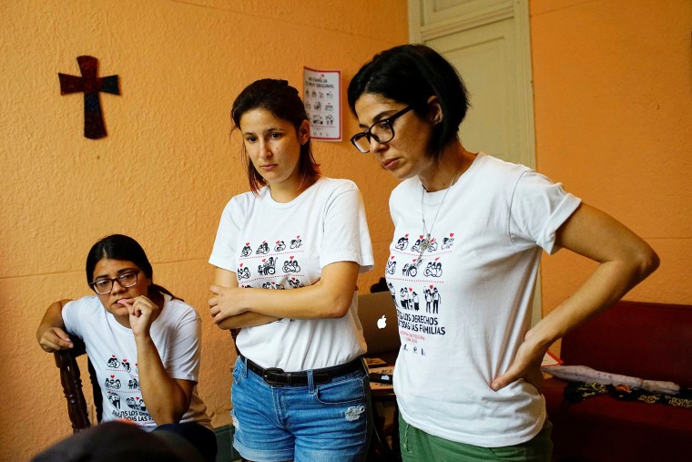 Image: Elaine Saralegui, Susana Hernandez and Angela Laksmi, activists supporting the lesbian, gay, bisexual and transgender community, talk to designers as they work in Havana