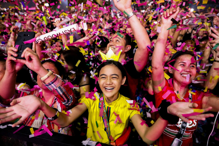Image: A reveller celebrates as confetti falls during a New Year's Eve party in Quezon City