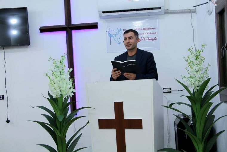 Image: Omar reads the Bible at the Church of the Brethren