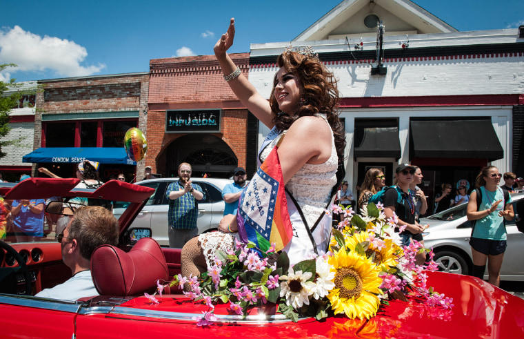 A participant waves from a car during Pride in Fayetteville, Arkansas, in 2018