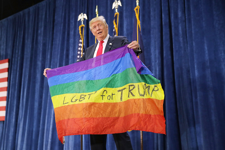 Image: Republican presidential nominee Donald Trump holds a rainbow flag