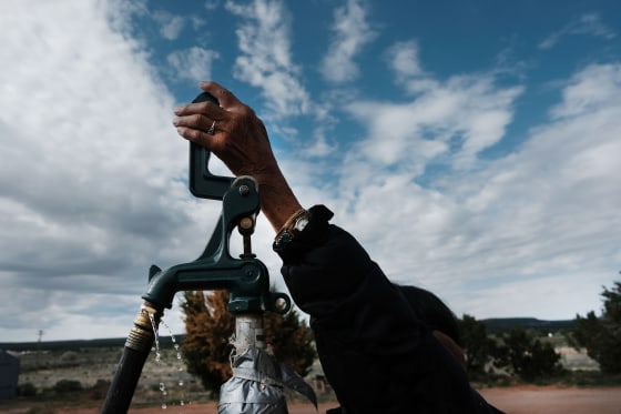 A member of the Navajo Nation fills bottles of water at a public tap in Thoreau, N.M., on June 5, 2019.
