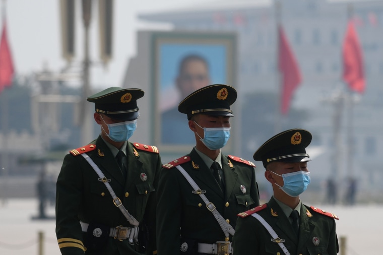 Paramilitary police officers wear masks as they patrol in Tiananmen Square in Beijing on May 1, 2020.Greg Baker / AFP - Getty Images