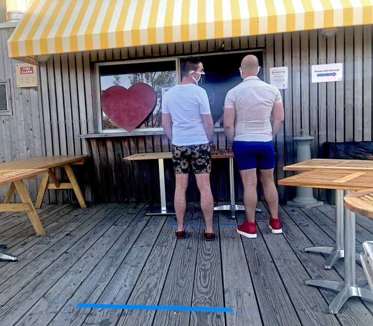 Two vacationers wear masks as they visit the Cantine in Fire Island Pines. 
