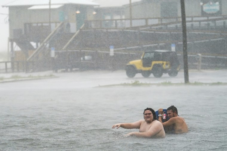 Imagen: La gente juega en un estacionamiento inundado en Navarre Beach, el martes 15 de septiembre de 2020, en Pensacola Beach, Florida.