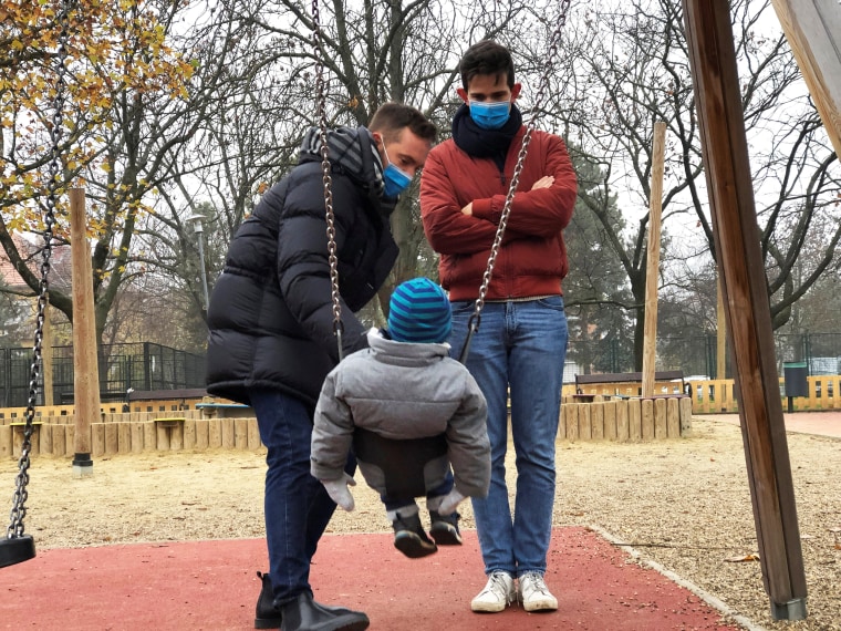 Image: Same sex couple Adam Hanol and Marton Pal play with their four year old adopted son Andras at a playground in Budapest