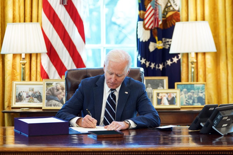 President Joe Biden signs the American Rescue Plan on March 11, 2021, in the Oval Office of the White House.