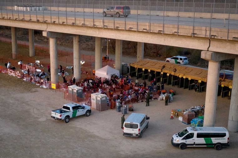 Image: Migrant families with children take refuge at a processing center under Anzalduas International Bridge in Granjeno, Texas