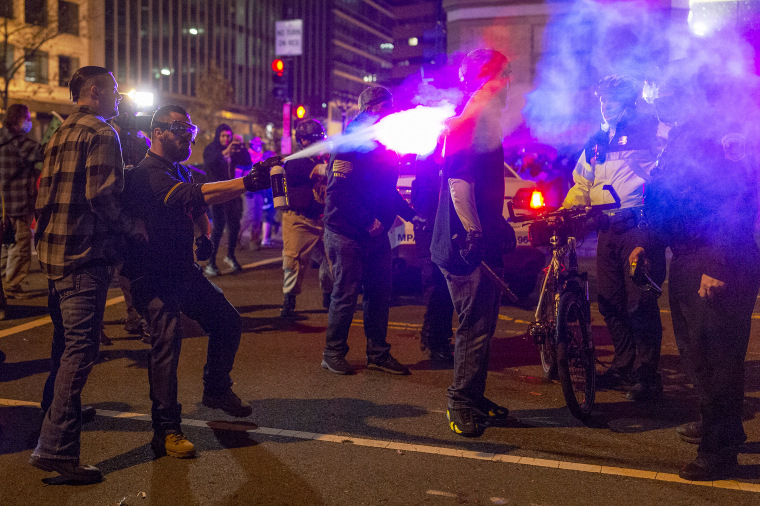 A member of the Proud Boys sprays a police officer with a chemical agent in downtown Washington as the group clashed continuously with counter-protesters on the evening of the second Million MAGA March in on Dec. 12, 2020.