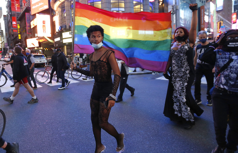 A protester holds a rainbow flag in support of transgender rights