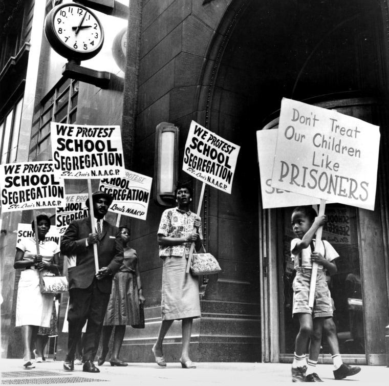 Demonstrators picket in front of a school board office in protest of segregation, in St. Louis, Mo., early 1960s.